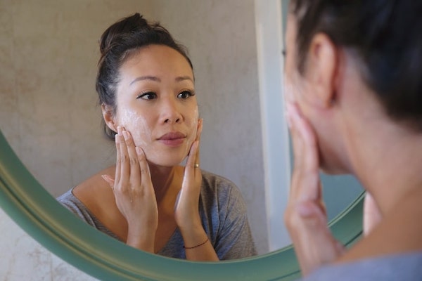 Woman exfoliating in mirror