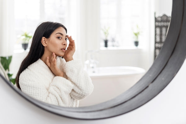 Biopelle Emepelle Asian woman checking her facial skin in the mirror